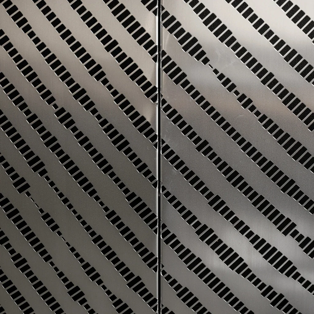 Close-up of perforated stainless steel panel, showing precise hole pattern and brushed finish.